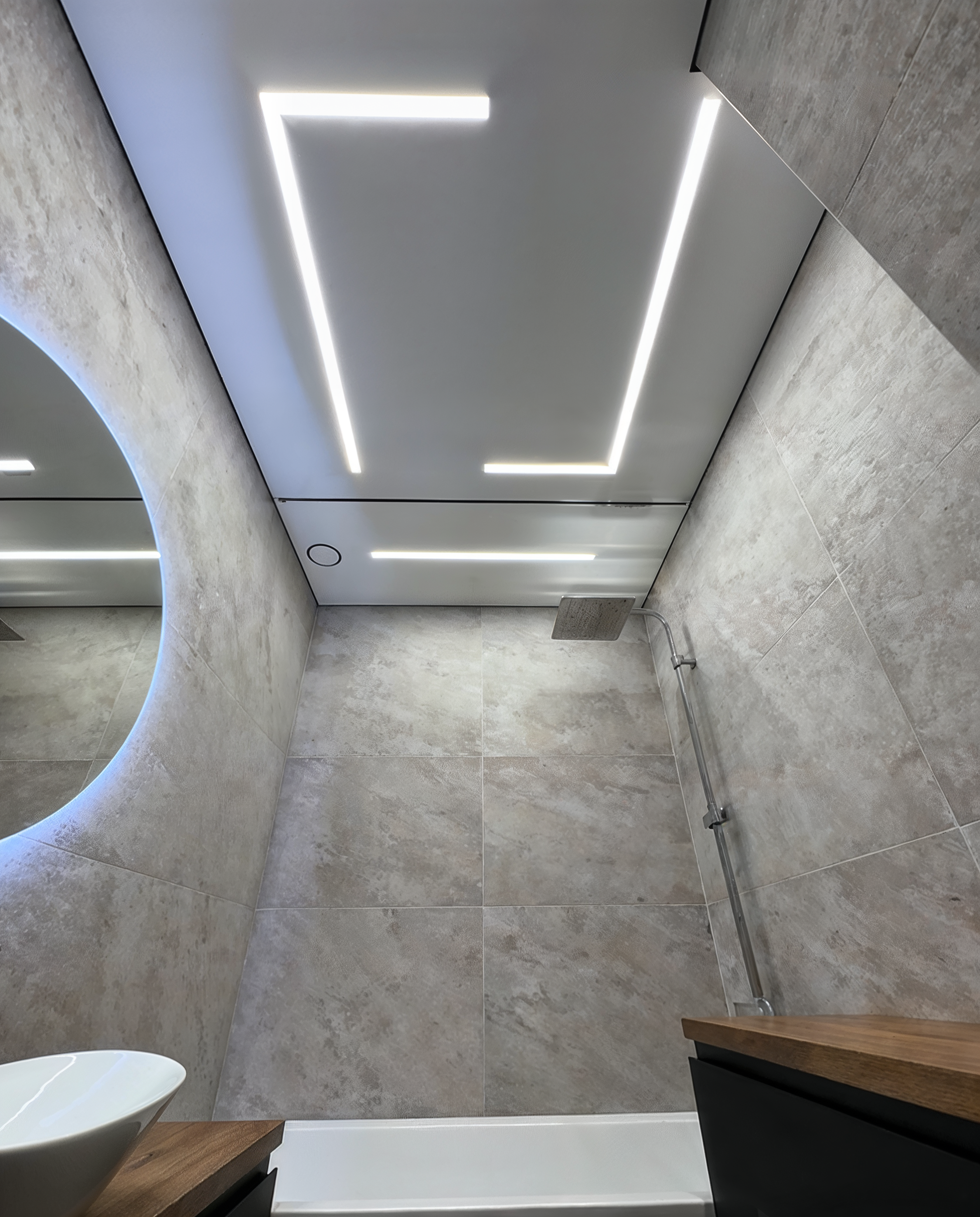 A perimeter light line framing the shower ceiling, mirrored below