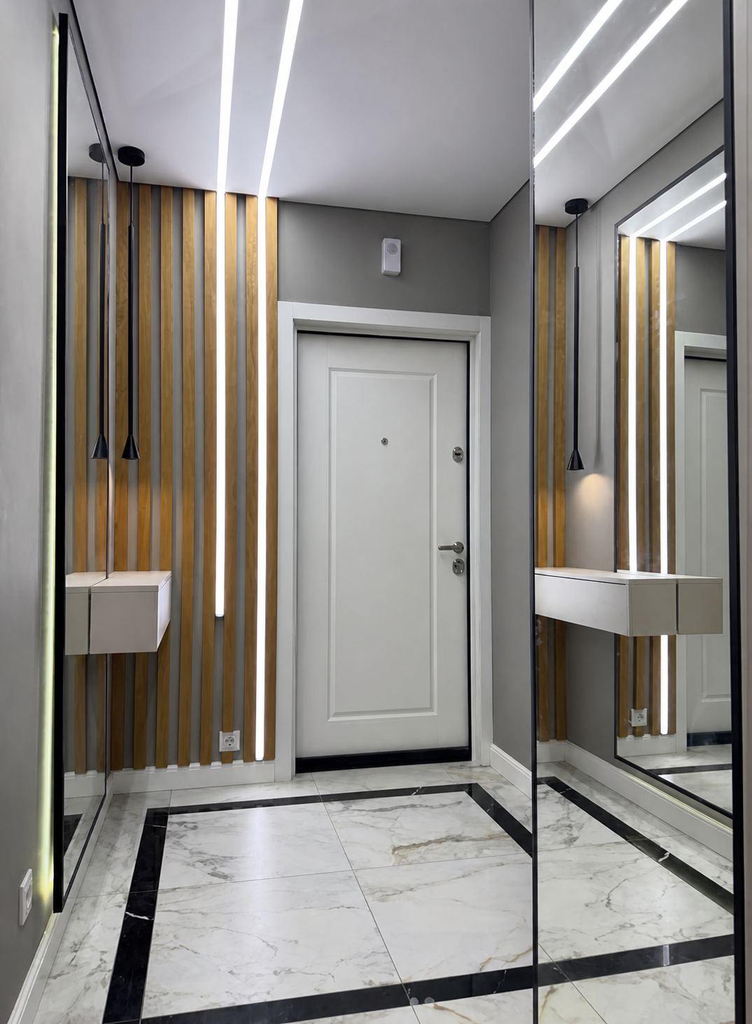 An entryway framed by ceiling and wall light lines