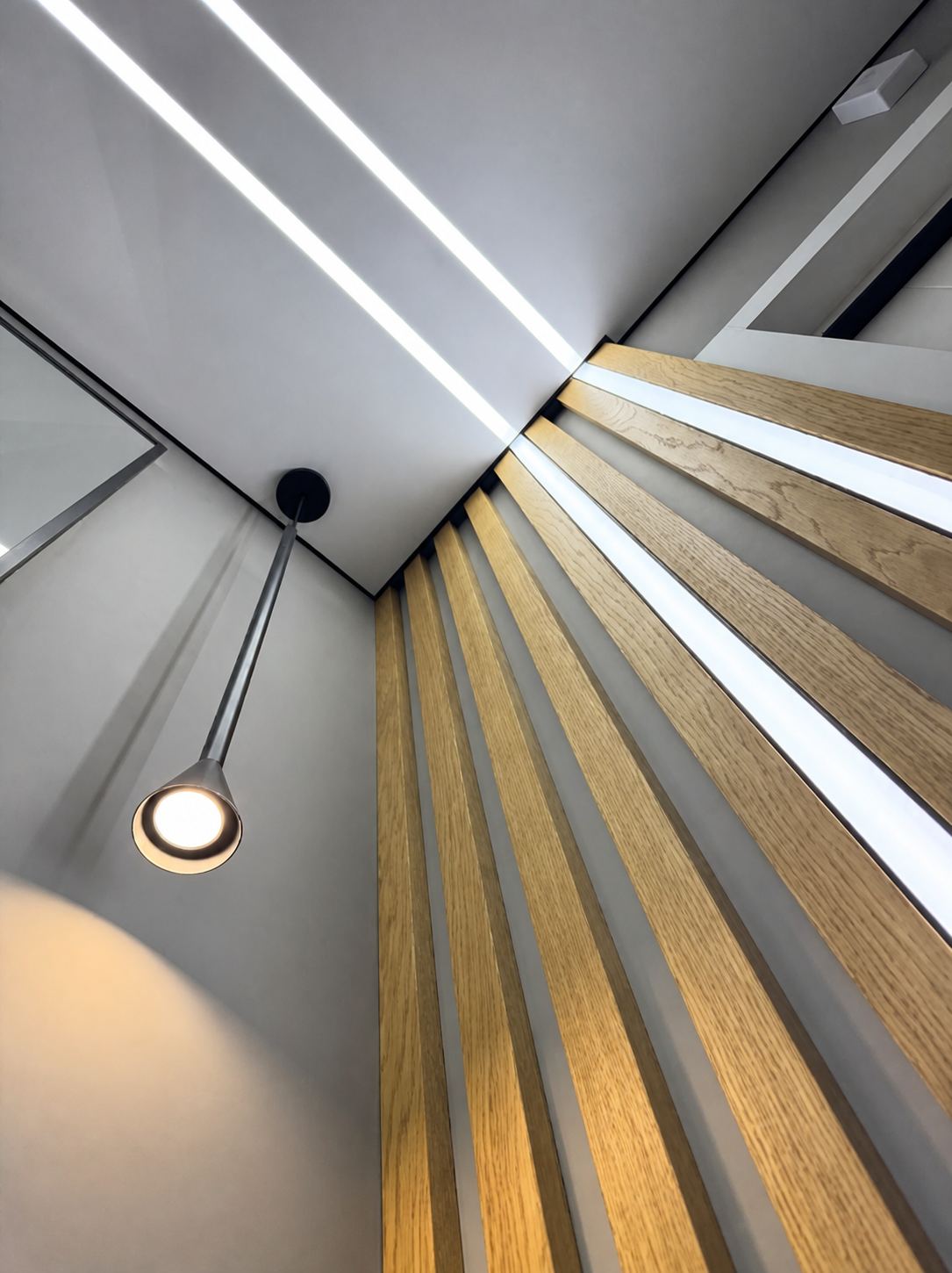 Parallel ceiling lines meeting a fanned wood feature