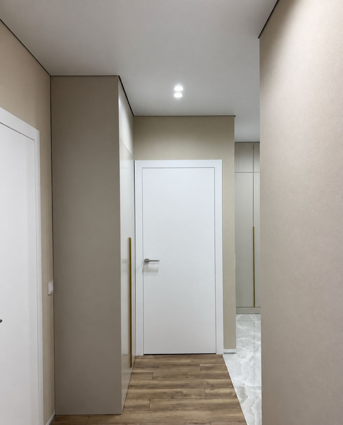 A trim-free entryway ceiling meeting a built-in wardrobe