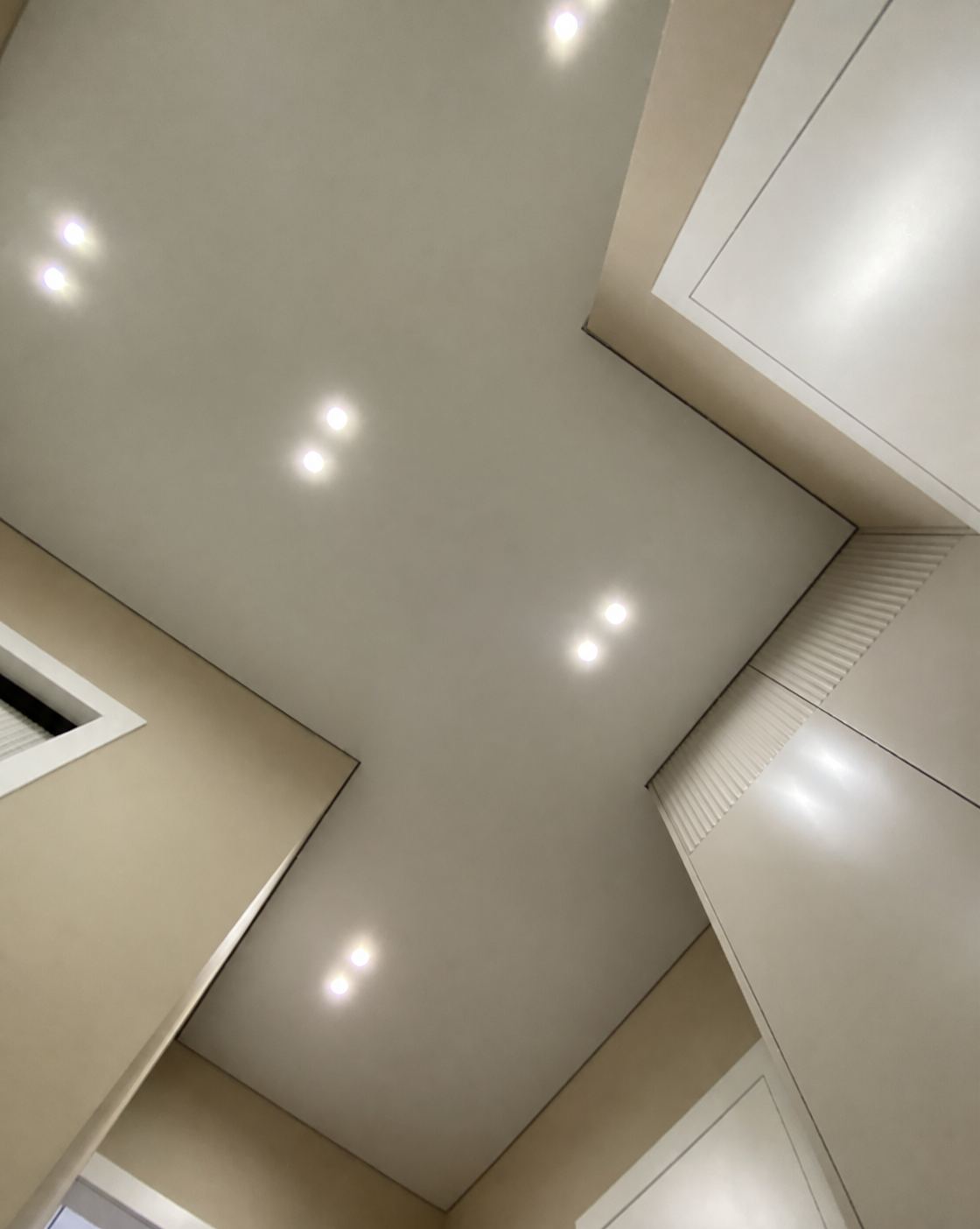 Recessed spotlights set into the shadow-gap ceiling plane