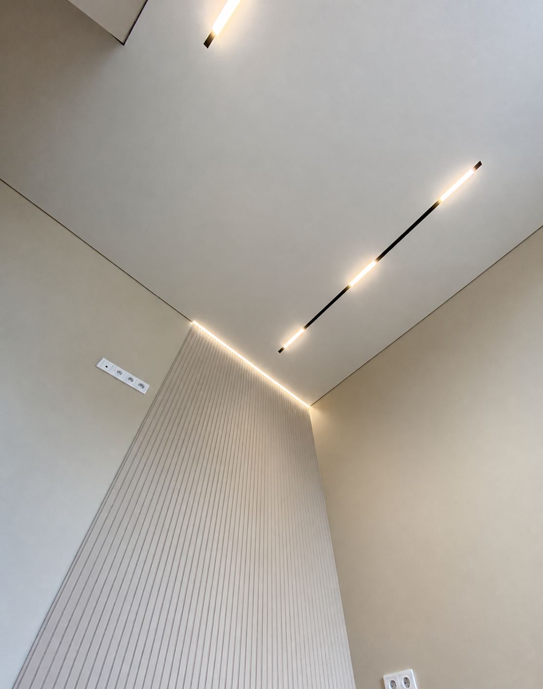 Shadow-gap edge meeting a fluted wall panel