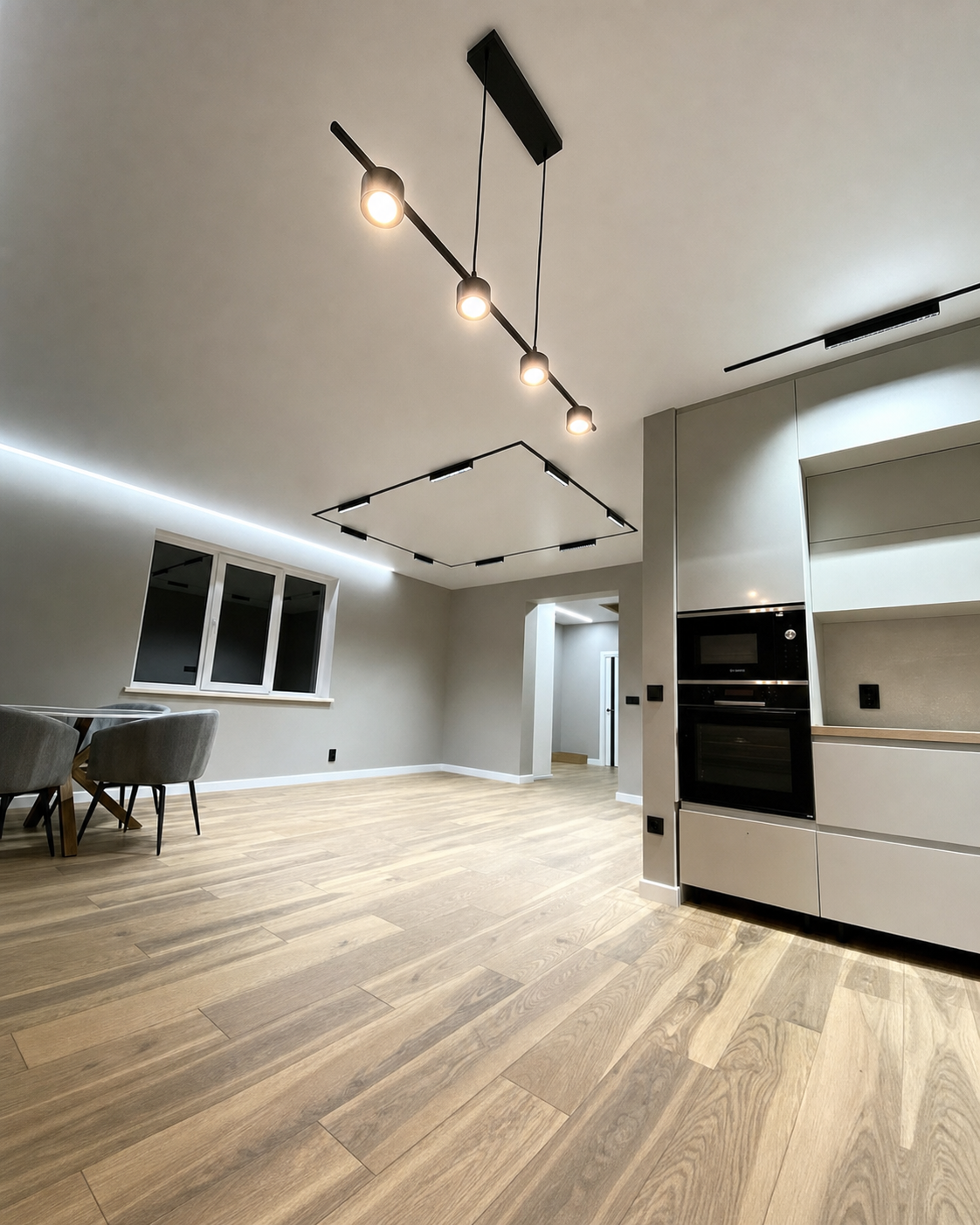 A square track detail paired with a linear pendant fixture above the table
