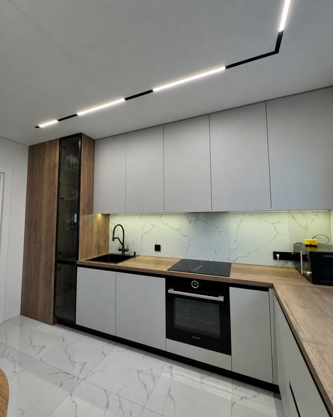 The track continuing above the cabinetry and backsplash